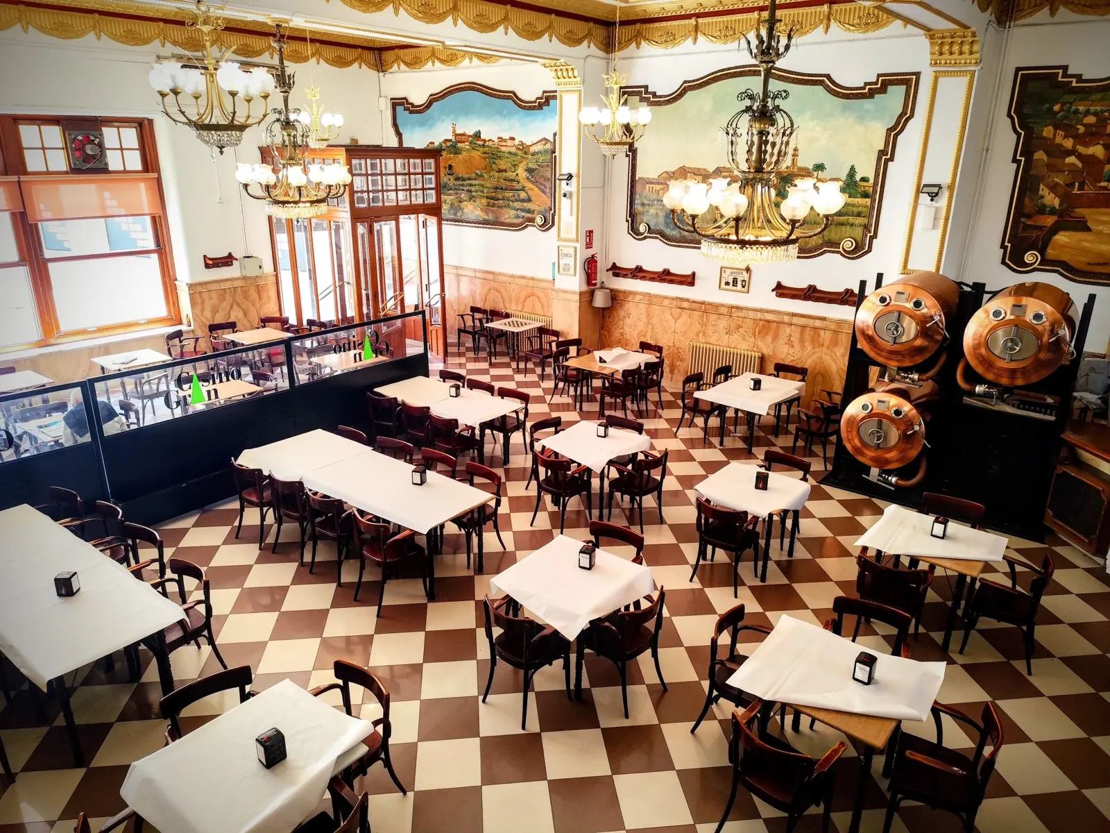 Comedor del Casino Gran con alambiques de cobre y murales pintados en las paredes