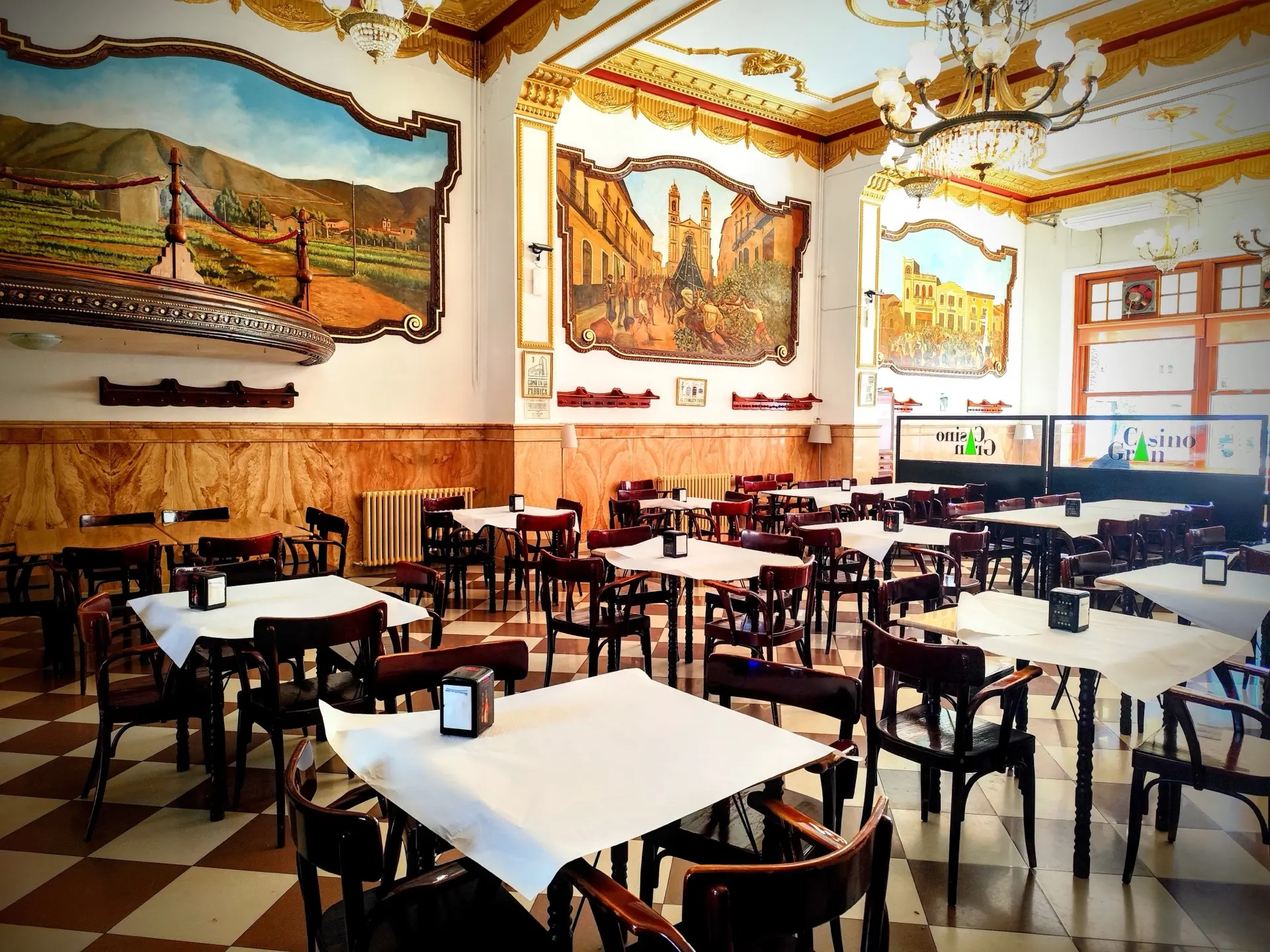 Salón interior del Casino Gran, con techos dorados, murales pintados y suelo de ajedrez